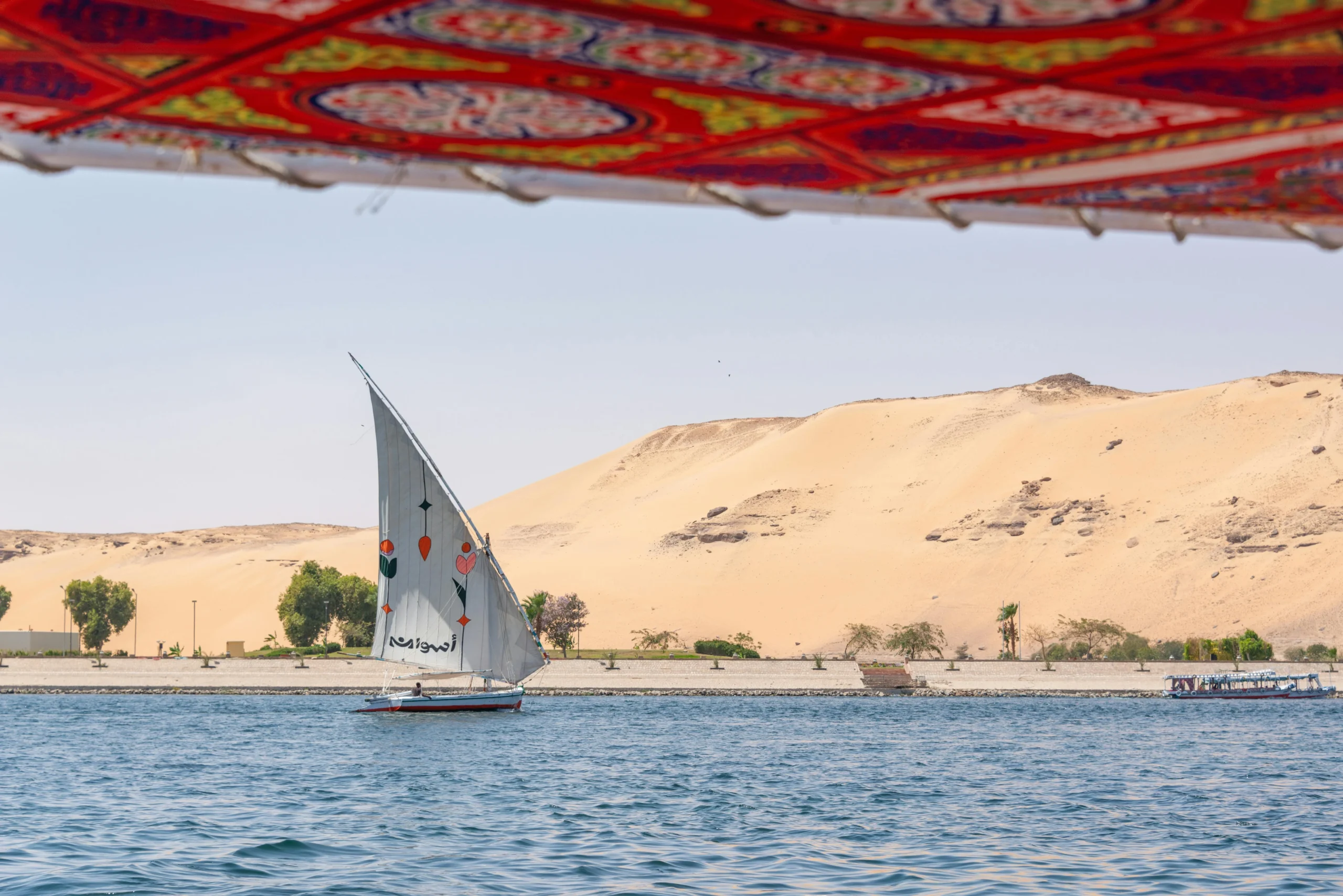 Tourists sailing on a Nile cruise with Heart Egypt Tours, surrounded by golden sunlight, ancient temples, and the serene beauty of Egypt’s timeless river.